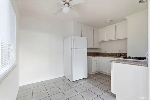 a kitchen with white cabinets and white appliances