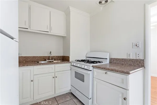 a kitchen with granite countertop white cabinets and white appliances