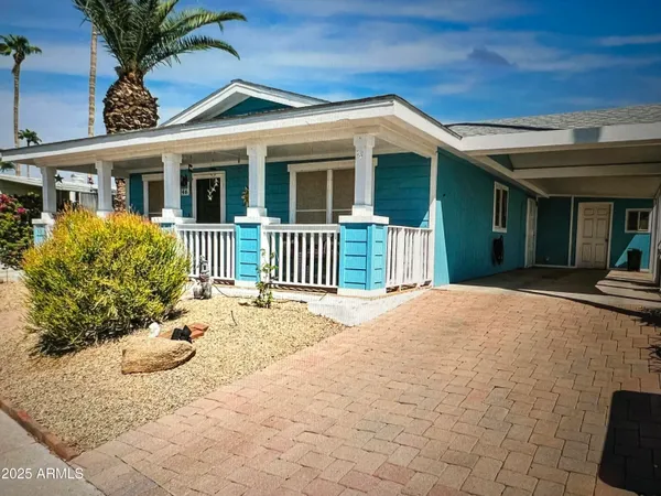 a view of a house with a yard and potted plants