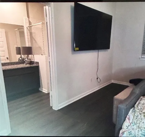 a view of a livingroom with wooden floor and a flat screen tv