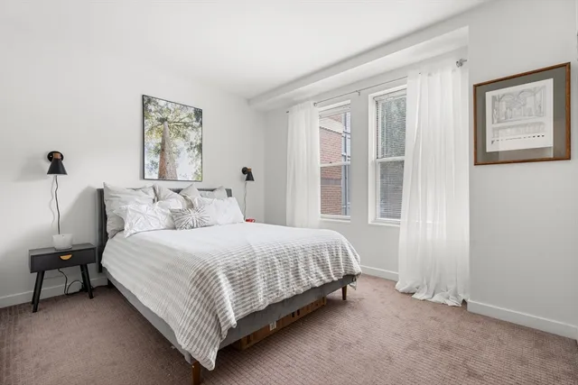 a large bed sitting in a bedroom next to a window