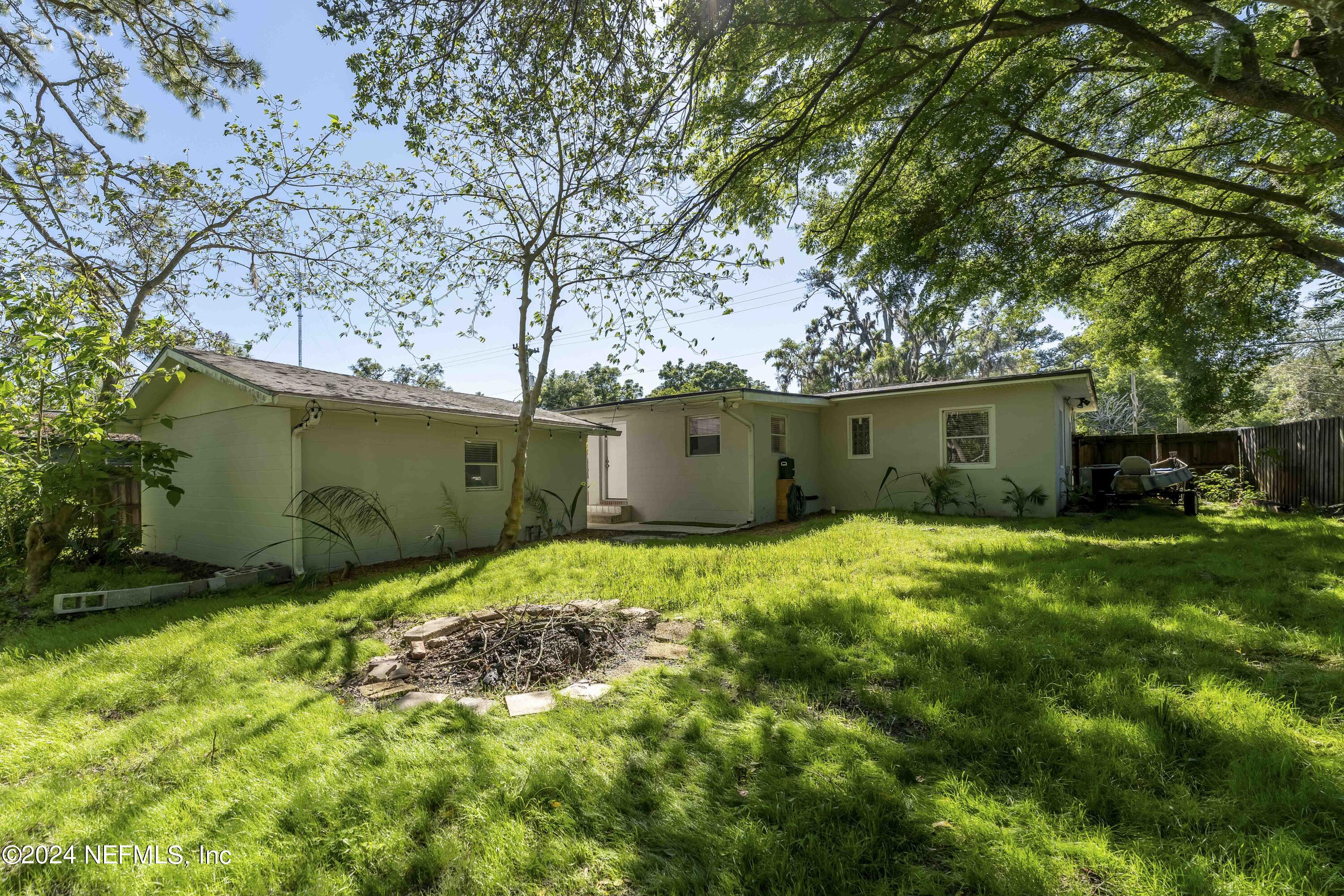 3651 Peach Drive Jacksonville, FL 32246 - Photo 22 of 25 a backyard of a house with plants and large tree