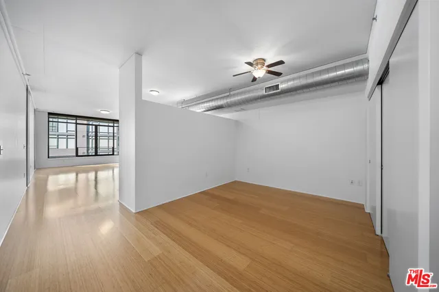 a view of a big room with wooden floor and a ceiling fan
