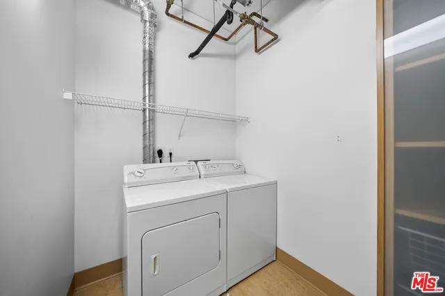 a view of a hallway with wooden floor and a bathroom