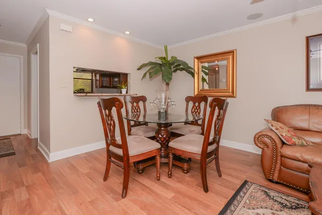 a dining room with furniture potted plants and wooden floor