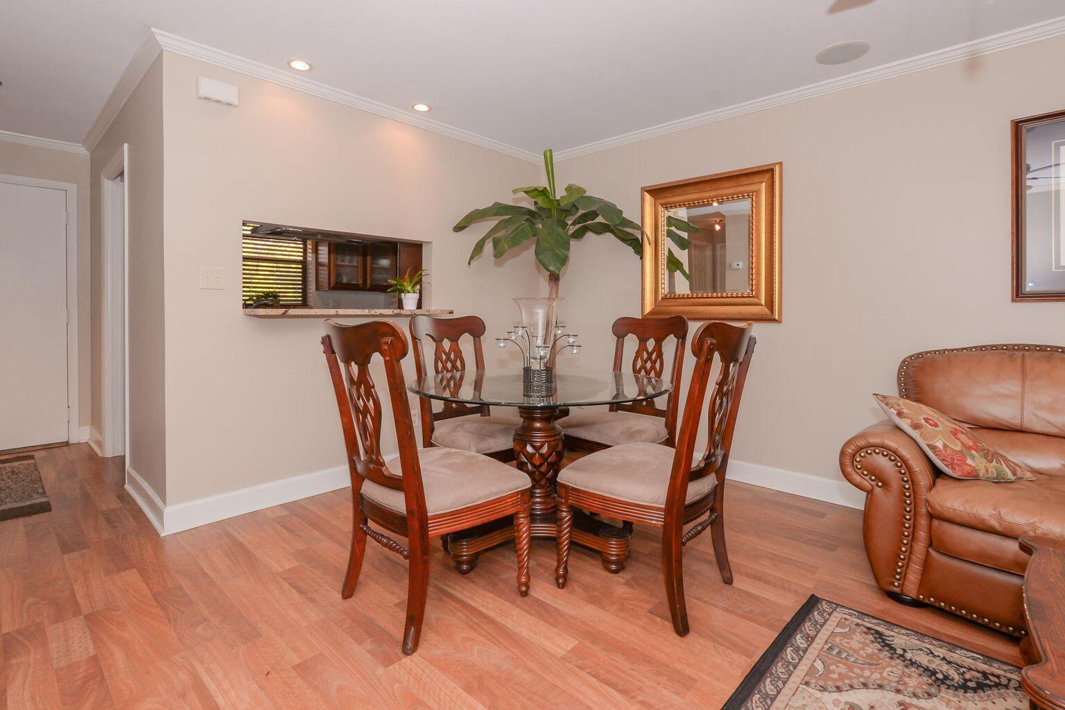 a dining room with furniture potted plants and wooden floor