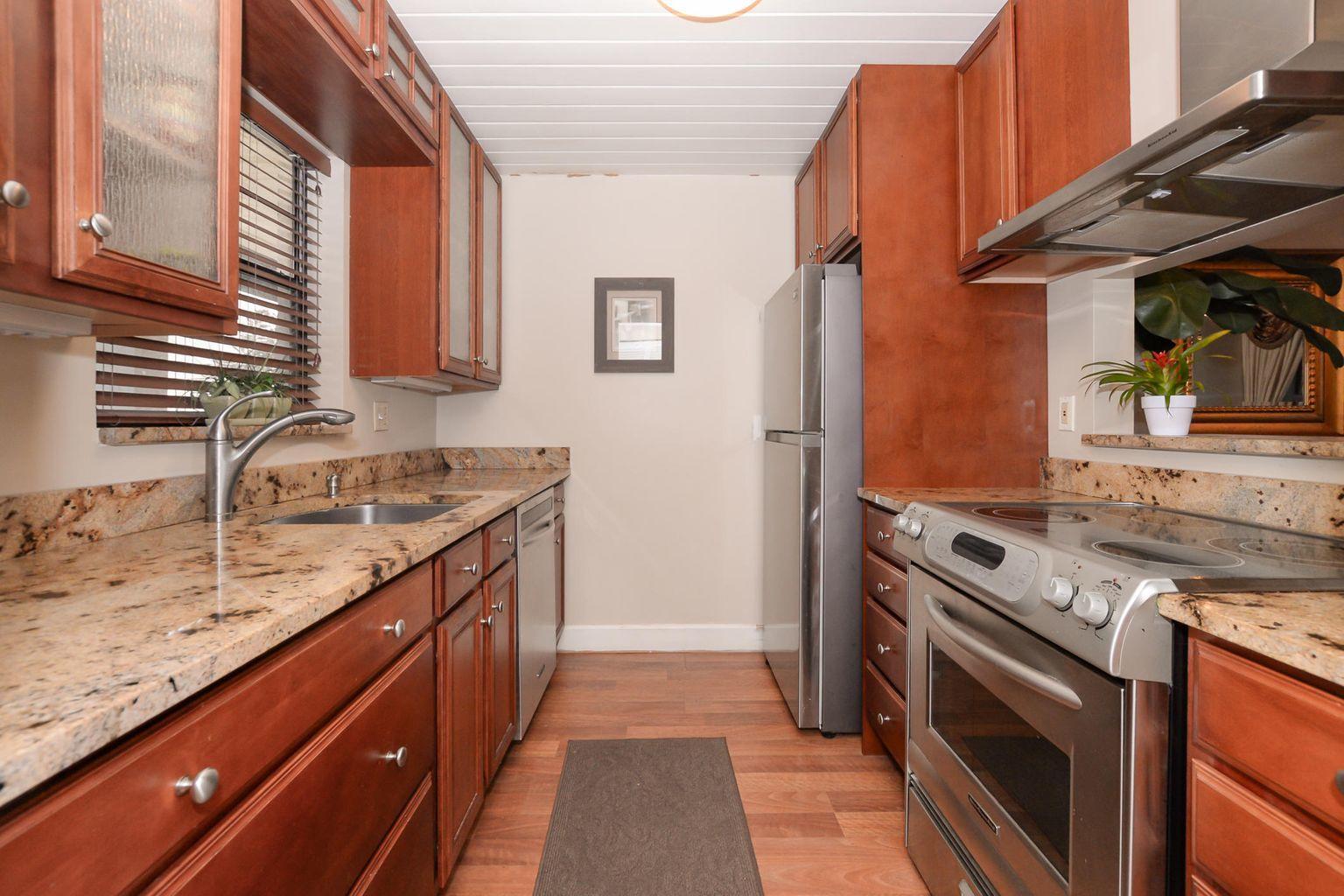 2050 Oleander Boulevard, Unit 2202 Fort Pierce, FL 34950 - Photo 15 of 15 a kitchen with granite countertop a sink stove and cabinets