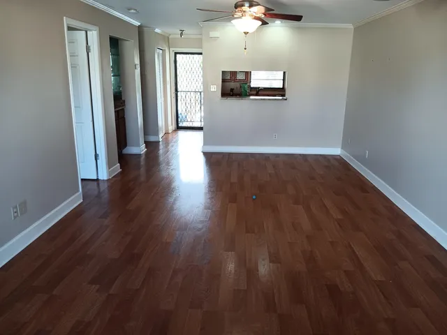 a view of a hallway with wooden floor and a chandelier