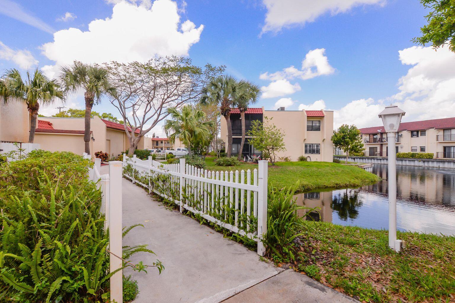 2050 Oleander Boulevard, Unit 2202 Fort Pierce, FL 34950 - Photo 10 of 15 a view of a garden with a bench in front of house
