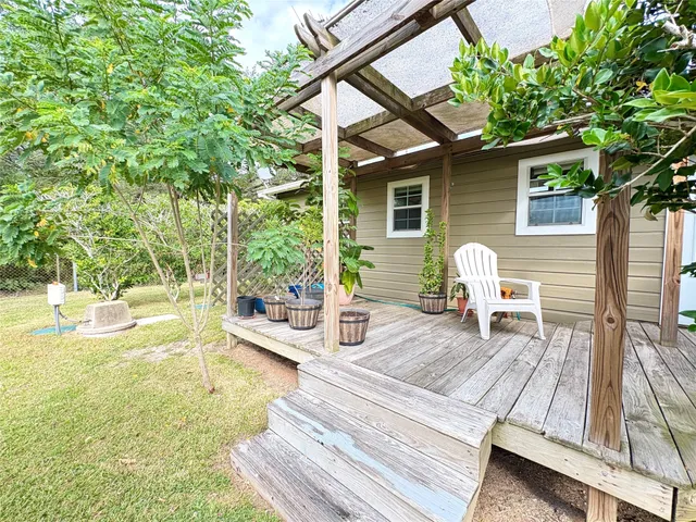 a view of a patio with table and chairs next to a large tree