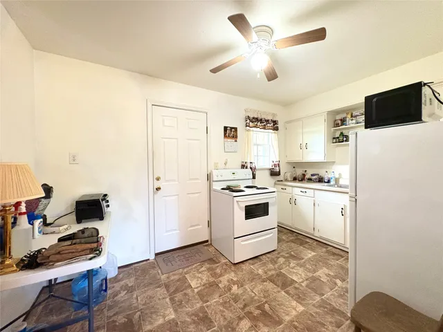 a white kitchen with sink stove and refrigerator