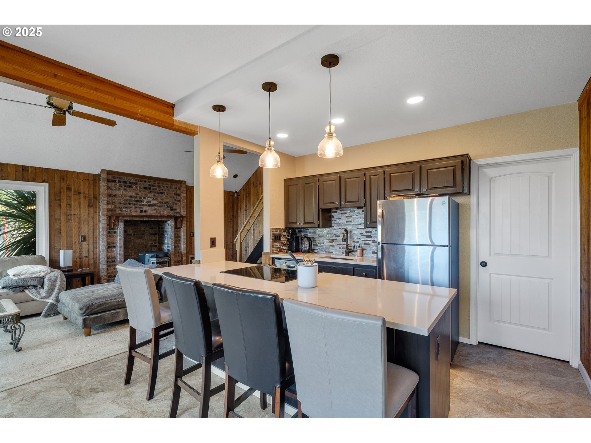 4900 Clam Way Tillamook, OR 97141 - Photo 19 of 30 a kitchen with stainless steel appliances kitchen island granite countertop a dining table chairs and a refrigerator