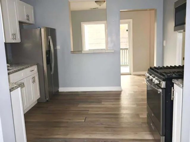 a kitchen with a refrigerator and a stove top oven