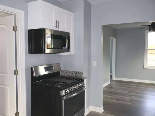 a kitchen with granite countertop a stove and a microwave