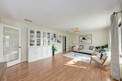 a living room with furniture and a wooden floor