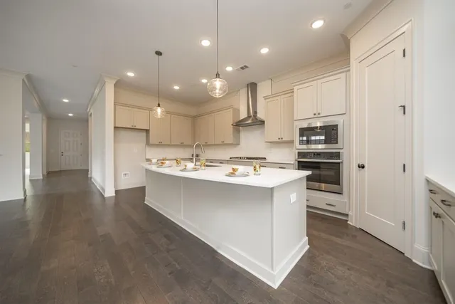 a kitchen with kitchen island a sink stainless steel appliances and cabinets