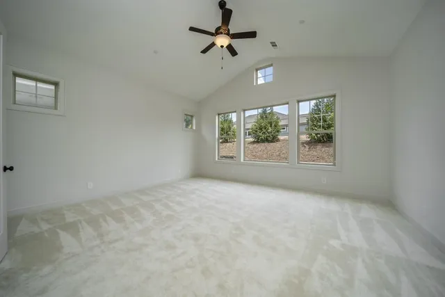 an empty room with windows and fan