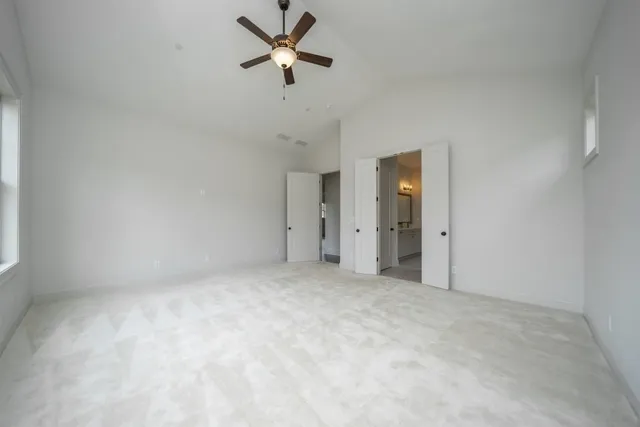 an empty room with a ceiling fan and a window