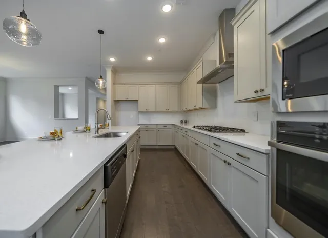 a kitchen with a sink stainless steel appliances cabinets and a counter top space