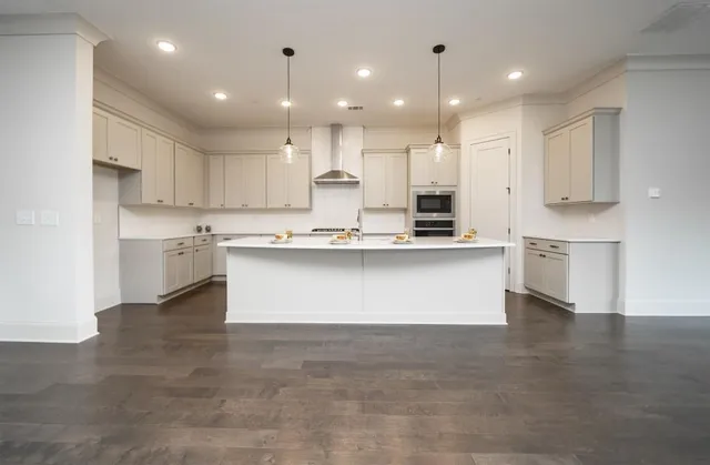 a large kitchen with kitchen island a stove a cabinets and a sink