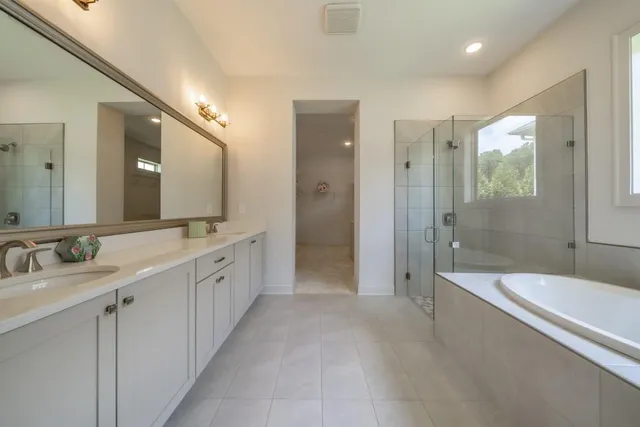 a large spacious bathroom with a granite countertop tub sink shower and mirror