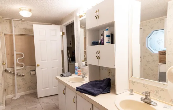 a bathroom with a granite countertop sink mirror and shower