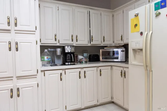 a kitchen with stainless steel appliances a white cabinets and a window