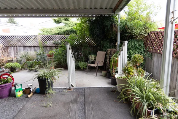a garden with a table and chairs and potted plants