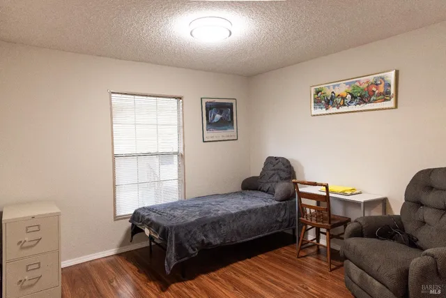 a bedroom with a bed wooden floor and a window