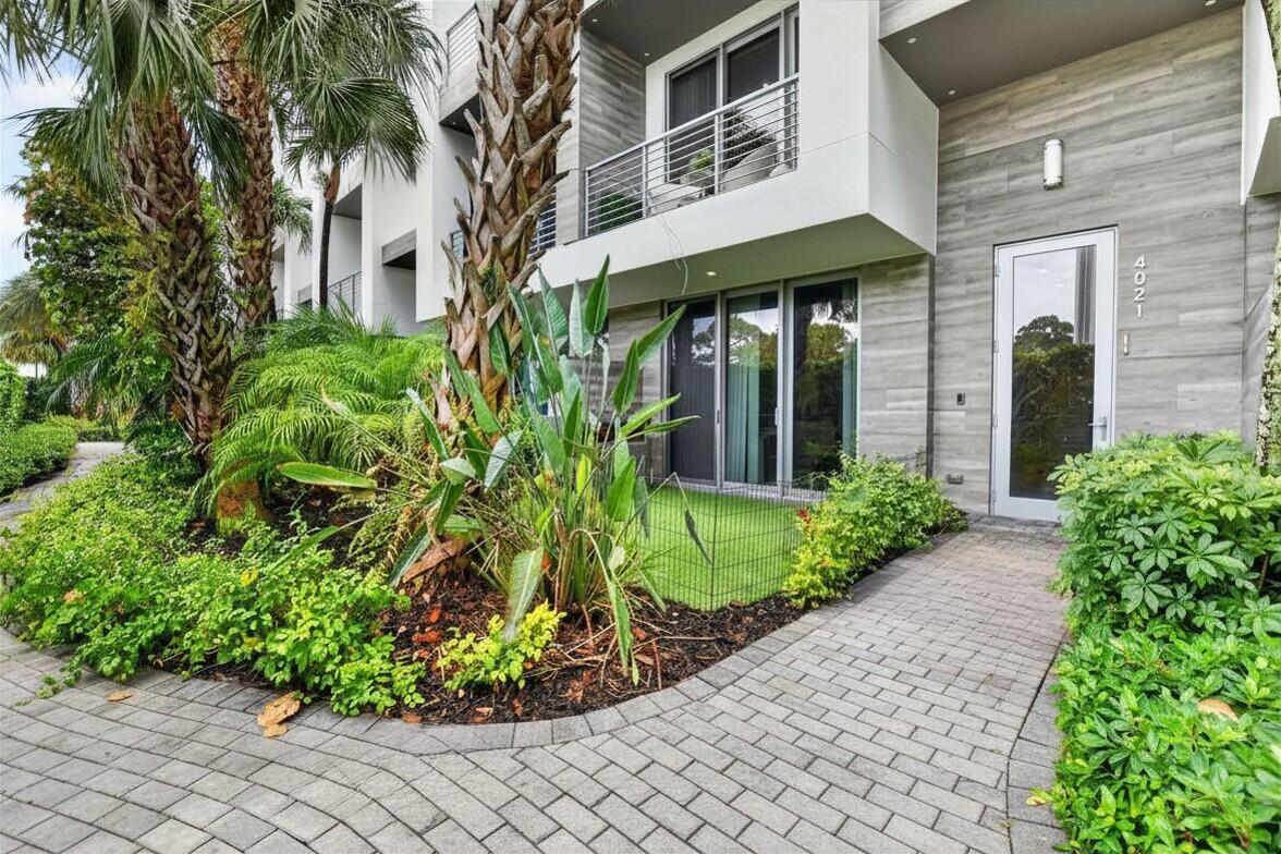 4021 Northwest 18th Way Boca Raton, FL 33431 - Photo 1 of 37 a view of a brick house with a large window and flower plants