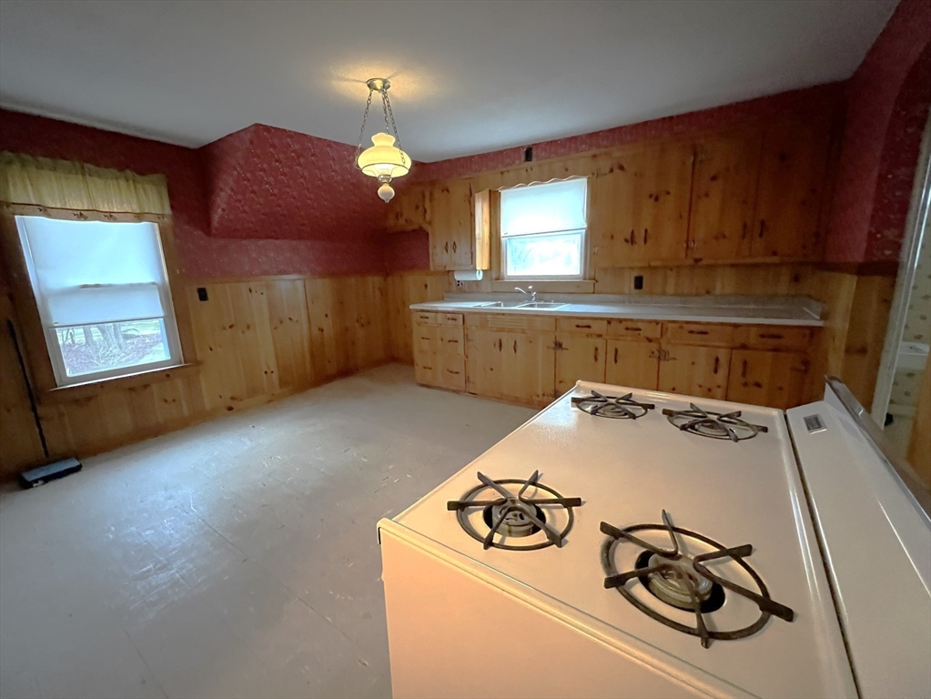 18 Eastern Avenue Webster, MA 01570 - Photo 24 of 36 a kitchen with a stove and a refrigerator