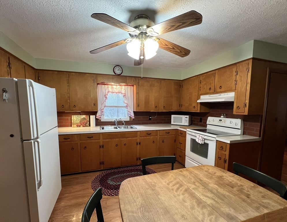 18 Eastern Avenue Webster, MA 01570 - Photo 8 of 36 a kitchen with stainless steel appliances granite countertop a refrigerator a sink dishwasher a stove and white countertops with wooden floor