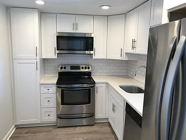 a kitchen with white cabinets and stainless steel appliances