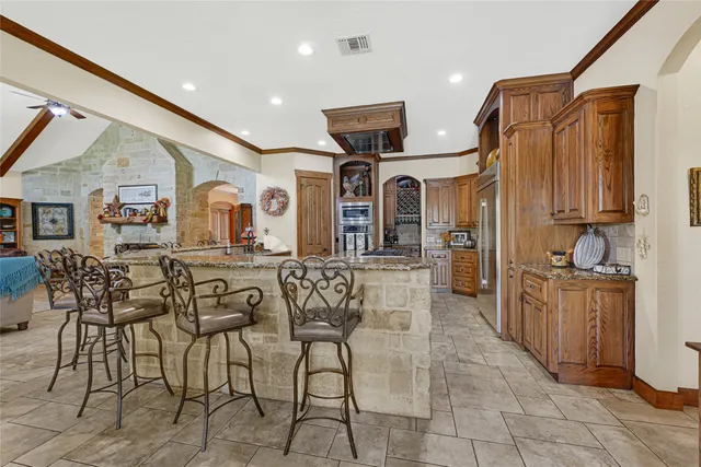 a kitchen with stainless steel appliances kitchen island granite countertop a refrigerator and microwave