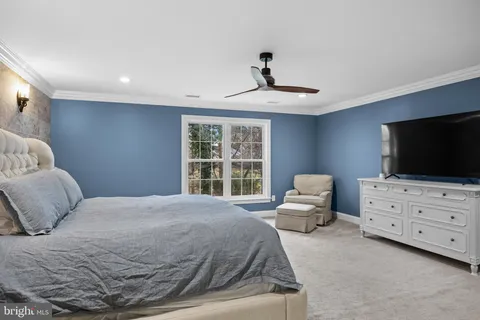 a spacious bedroom with a bed and a flat screen tv