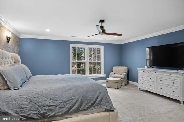 a spacious bedroom with a bed and a flat screen tv