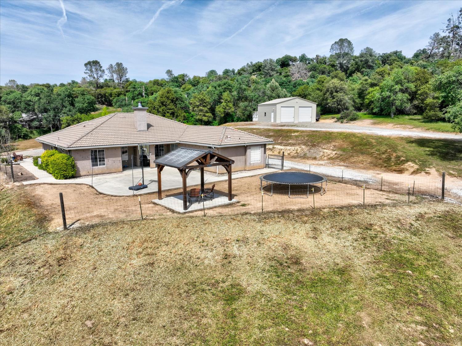 47482 Veater Ranch Road Coarsegold, CA 93614 - Photo 41 of 51 a view of a patio with a table and chairs under an umbrella