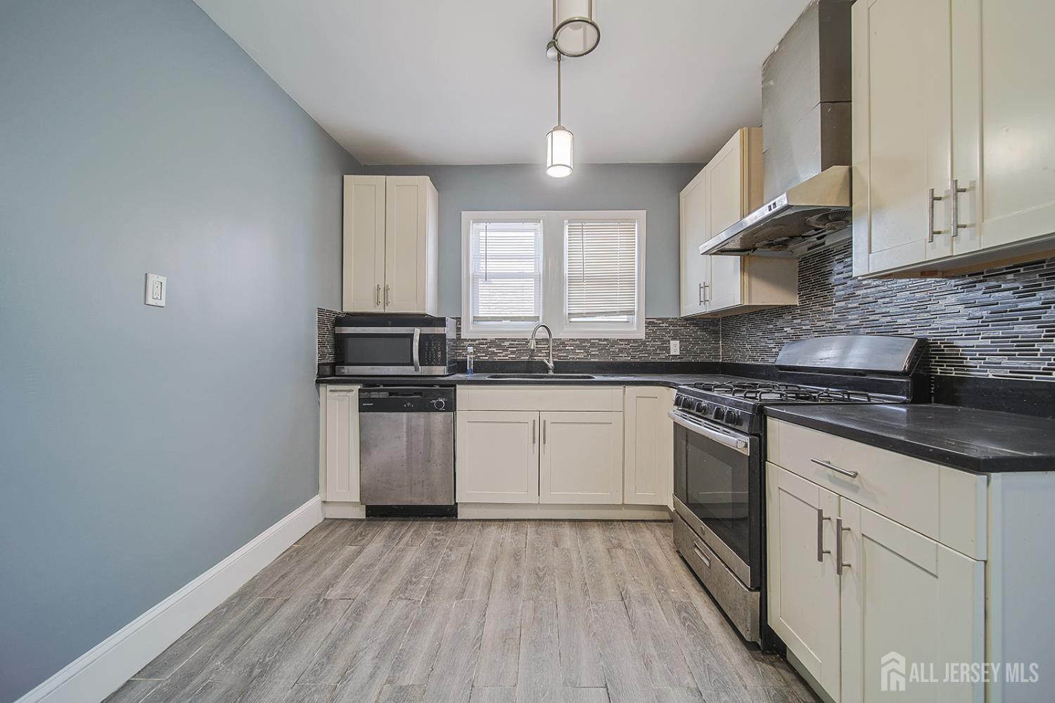 9 Rolfe Avenue Highland Park, NJ 08904 - Photo 5 of 8 a kitchen with granite countertop stainless steel appliances a sink window and cabinets