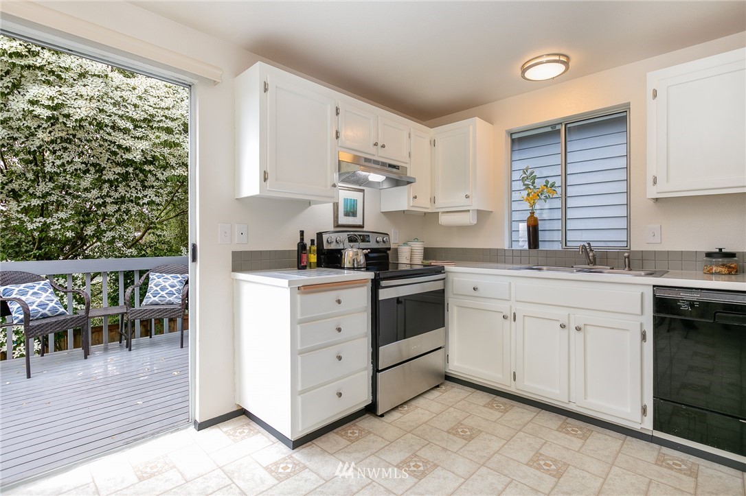 741 North 87th Street Seattle, WA 98103 - Photo 11 of 20 a kitchen with granite countertop white cabinets and white appliances