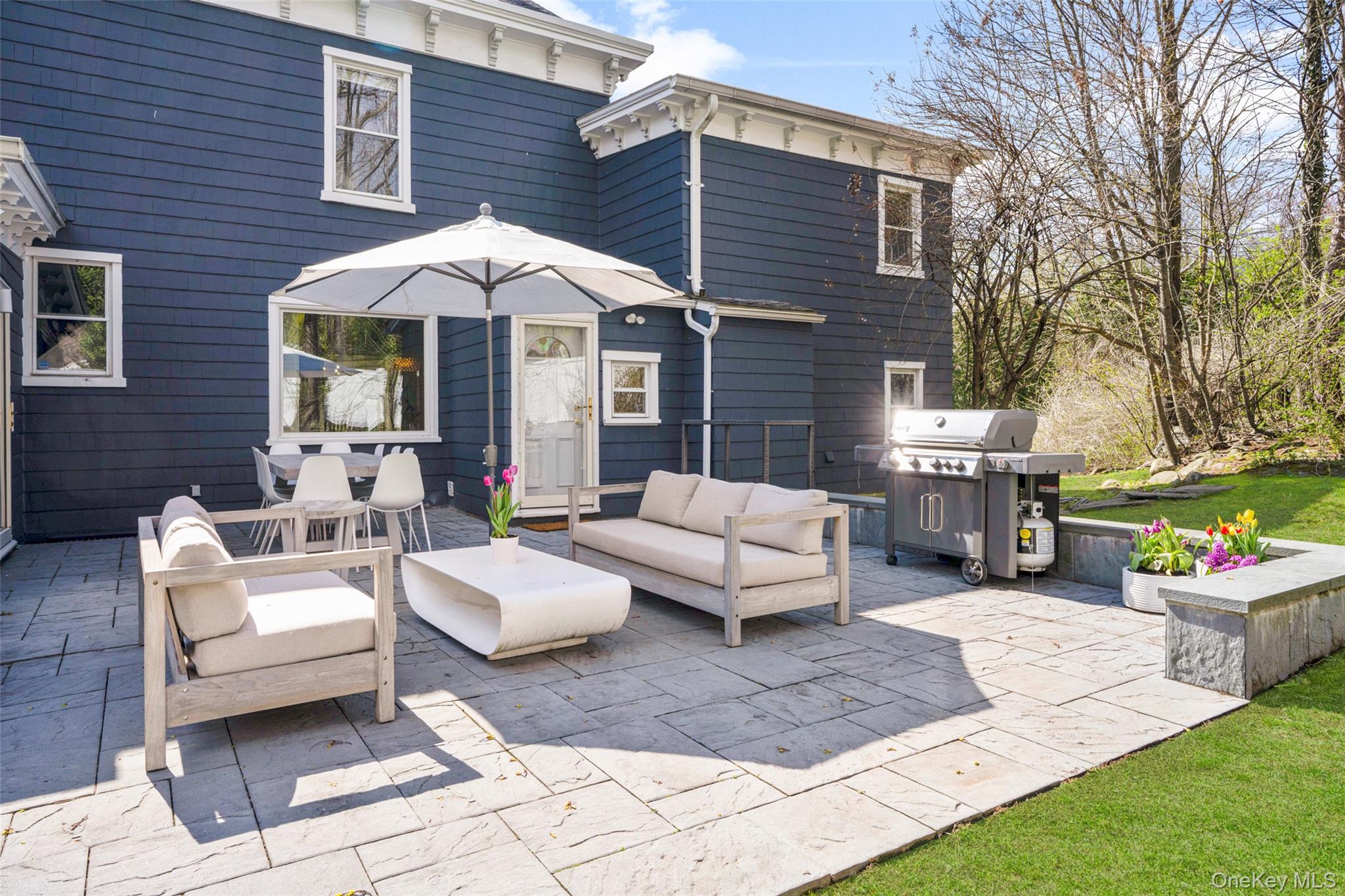 644 Fort Hill Road Scarsdale, NY 10583 - Photo 37 of 42 a view of a patio with couches table and chairs under an umbrella