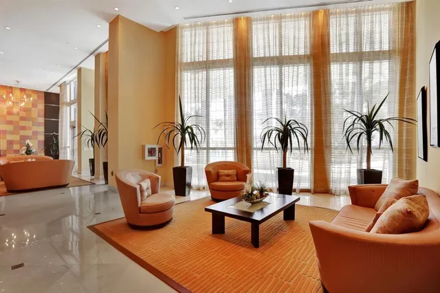 a living room with furniture and white kitchen