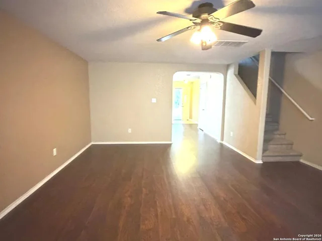 a view of an empty room with window and wooden floor