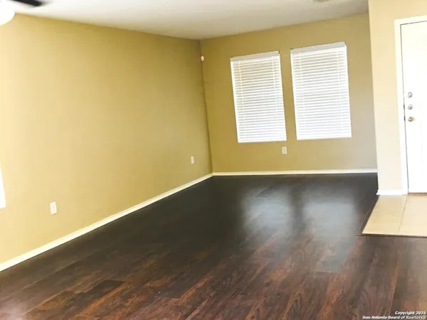 a view of a room with wooden floor and a window