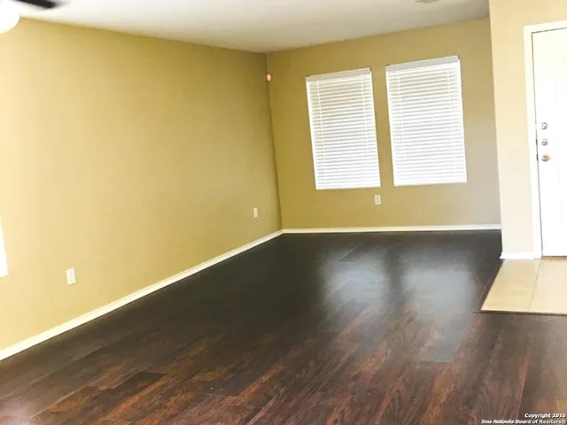 a view of a room with wooden floor and a window