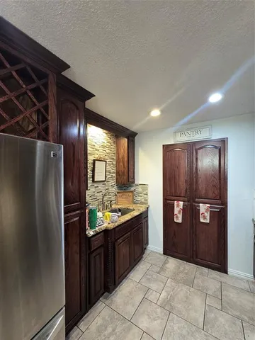 a kitchen with stainless steel appliances granite countertop a refrigerator and a sink