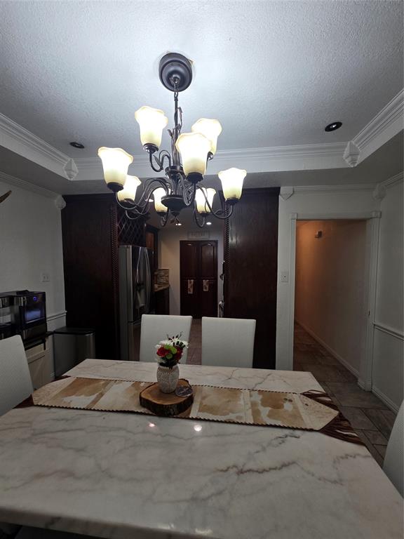 222 West Shady Grove Road, Unit 222 Irving, TX 75060 - Photo 15 of 37 a bedroom with a large bed and a chandelier