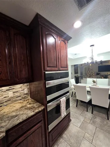 a living room with couches and kitchen view with wooden floor