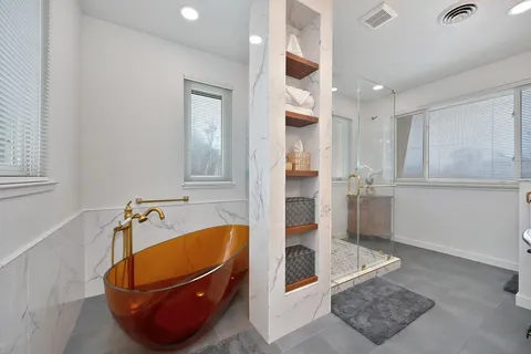 a bathroom with a sink mirror and a tub