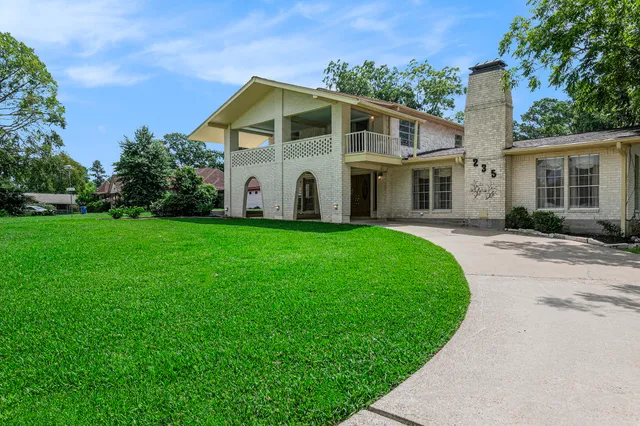 a front view of a house with a garden and yard