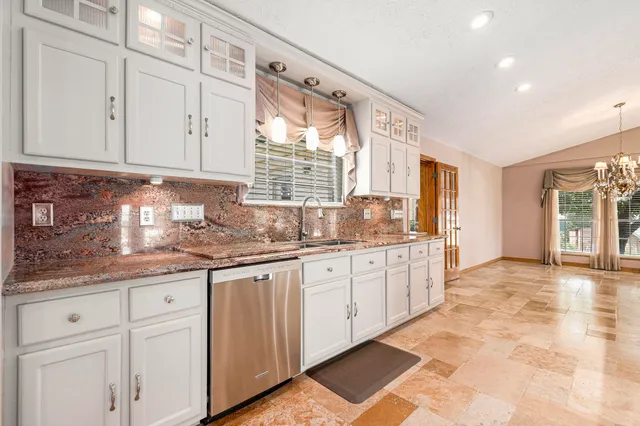 a view of a kitchen with kitchen island a sink stainless steel appliances and cabinets